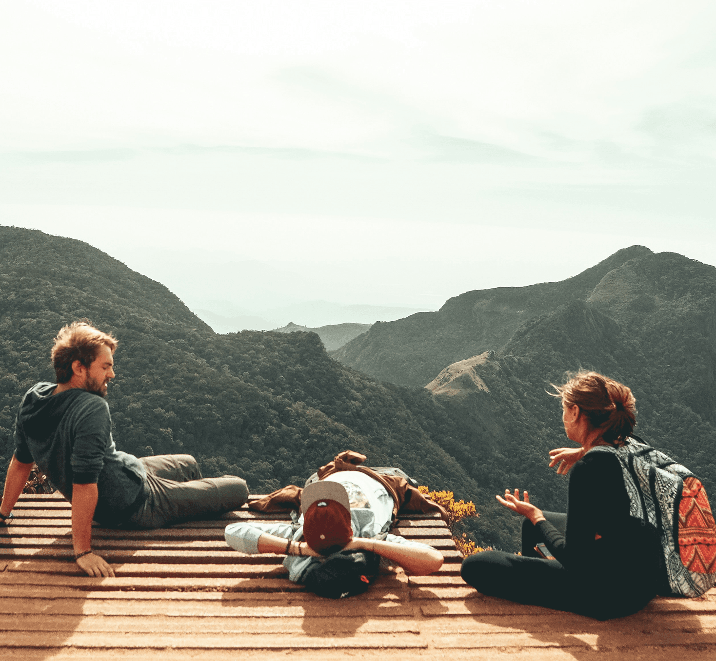 Menschen entspannen auf einer Holzterrasse mit Bergblick